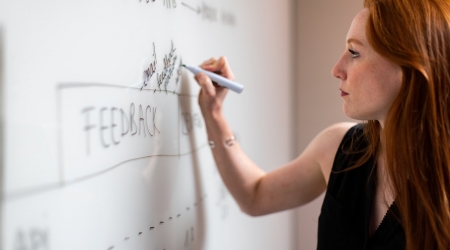 woman-in-black-sleeveless-top-writing-on-whiteboard HD